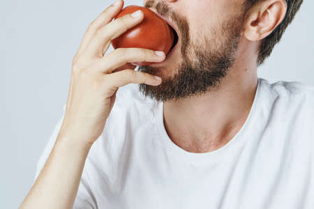 Vegetarian eating tomato close-up, diet, calories.の写真素材