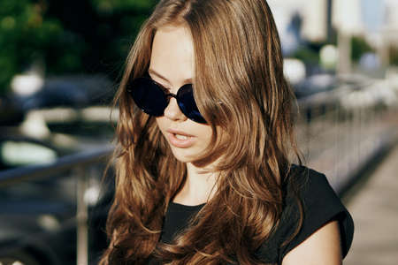 Young beautiful woman in sunglasses on the street in the city, megapolis.の写真素材