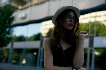 Young beautiful woman in sunglasses and in a white hat in the city.の写真素材