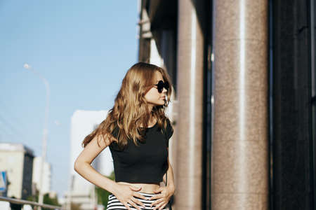 Young beautiful woman in sunglasses outdoors in the city.
