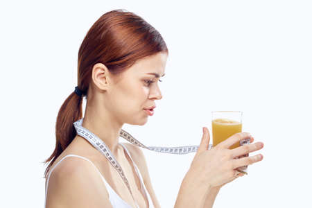 Beautiful young woman on white isolated background holds fresh squeezed juice, diet, fitness,...