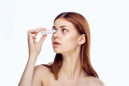A beautiful young woman on a white background isolated eyes bites, pharmacy.の写真素材
