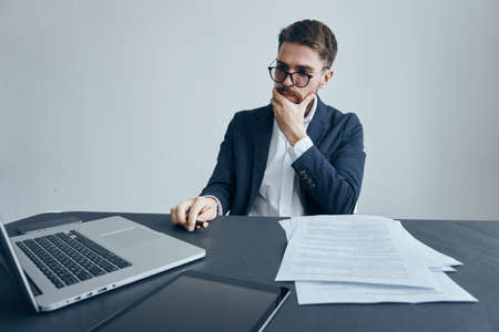 Business man with a beard in glasses working at his desk in the office.