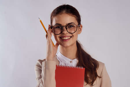 Young beautiful woman on a light background with glasses, teacher, study.の写真素材