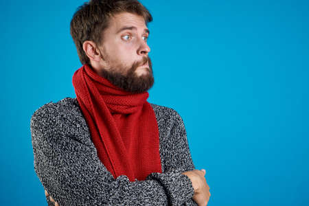 a man with a beard on a blue background, sick, illness, winter, emotion.の写真素材