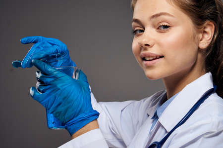 Young beautiful woman in medical clothes on a black background, doctor, medicine.の写真素材