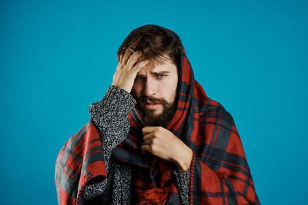a man with a beard on a blue background in a blanketの写真素材