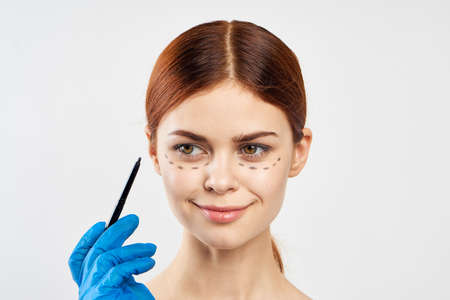 Young beautiful woman on white isolated background holds a markerの写真素材