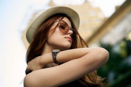 Beautiful young woman with hat and sunglasses outdoors in the city.の写真素材