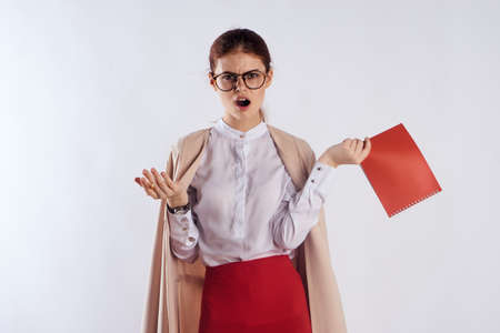 Young beautiful woman with glasses on white isolated background holds homework, teacher.