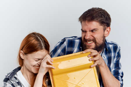 Young beautiful woman on a white background with a man with a beard holding construction tools for repair.の写真素材