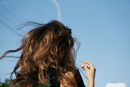 Woman running, sky, city, street, wind, summer, long hair.の写真素材