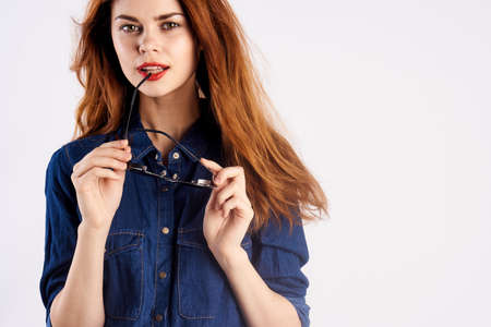 Young beautiful woman on white isolated background holds glasses, fashion, beauty.の写真素材