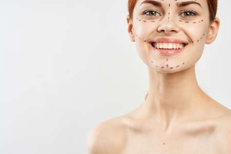 Young beautiful woman with contour for plastics on face on white isolated fn, smile, blank space for copy.の写真素材