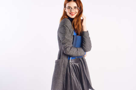 Young beautiful woman on a light white background with glasses, documents, teacher.の写真素材