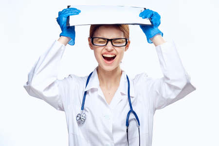 Young beautiful woman in glasses on white isolated background, documents, medicine, doctor, portrait, emotion, cry.の写真素材