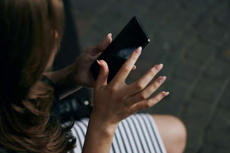 Woman holding a phone, close-up, hands, nails.の写真素材