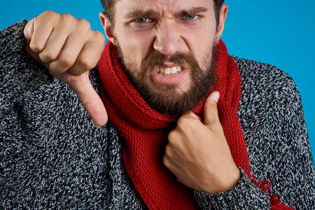 Man with a beard on a blue background, portrait, emotion, illness, sick.