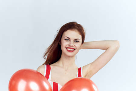 Beautiful young woman on a white background holds balloons, portrait.の写真素材