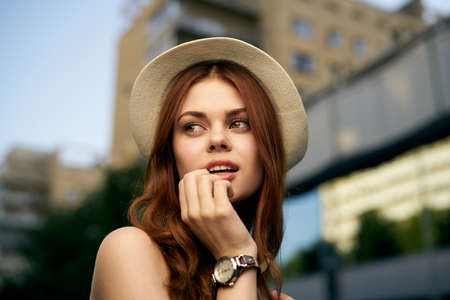 Beautiful young woman in a light hat outdoors in the city, portrait.の写真素材