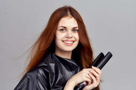 Young woman on a light gray background holds a ploy, hairstyle, portrait, style.の写真素材