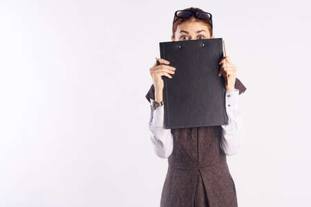 Young woman on white isolated background holding documents, teacher, blank space for copy.の写真素材