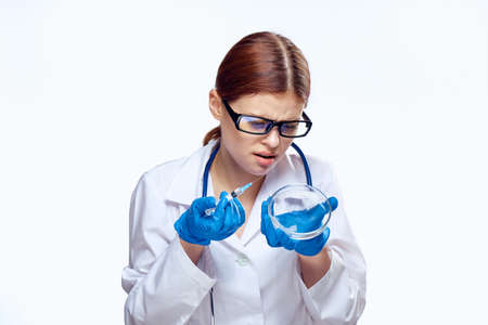 Woman holding a petri dish and a syringe, doctor.の写真素材