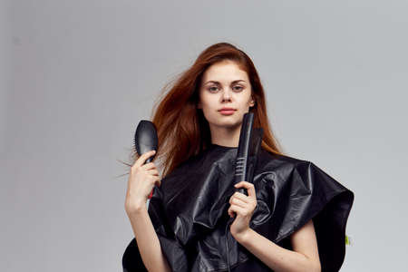 Young woman holding a curling iron, a hairdresser.の写真素材