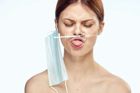 A woman on her lips holds a syringe.の写真素材