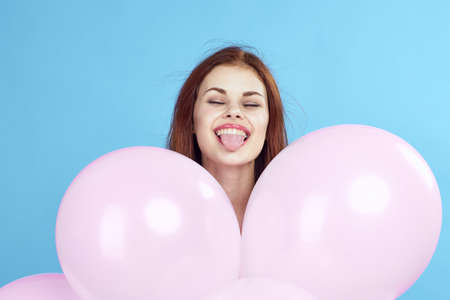Woman holding balloons, smiling.の写真素材