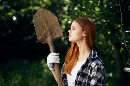 Woman holding a shovel in the garden.の写真素材