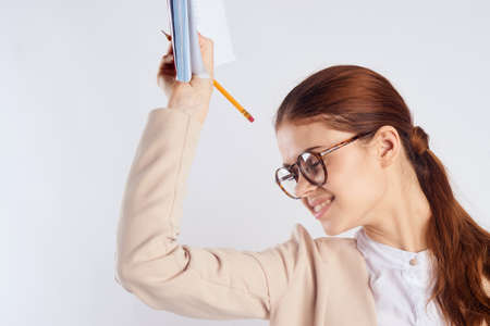 Woman teacher with glasses holds a notebook.の写真素材