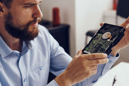 A man with a beard is repairing a computer.
