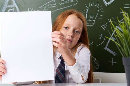 schoolgirl holds an empty album, school, pupil.の写真素材