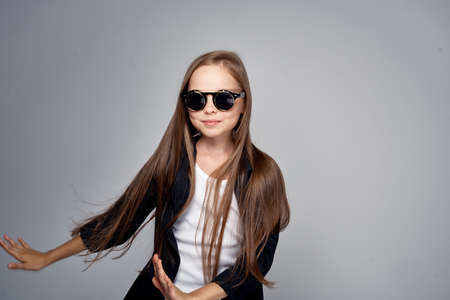 Girl in sunglasses on a black background, long straight hair.の写真素材