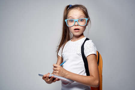 girl with glasses writes in notebook.の写真素材