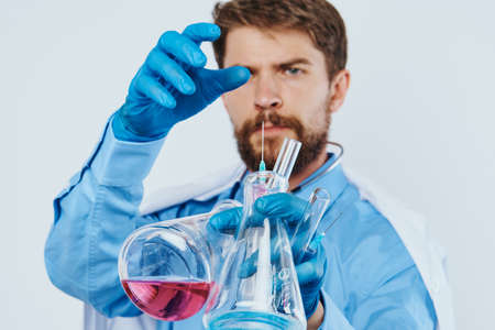 the man is holding laboratory utensils.の写真素材