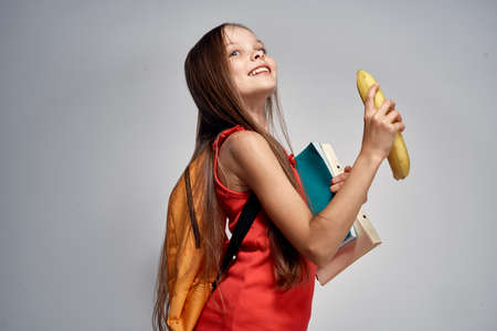 child, girl holding a banana, school.の写真素材