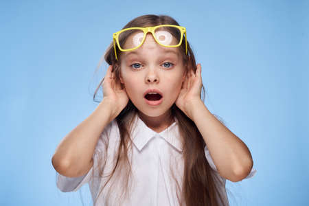little girl adjusts glasses, portrait, emotions.の写真素材