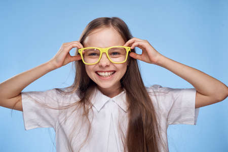 little girl in yellow glasses smiles and laughs, portrait.の写真素材