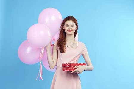 young woman holds pink balloons.の写真素材