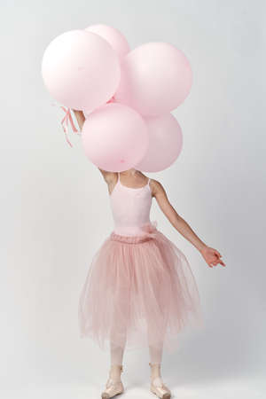 girl in a ballerina skirt holds balloons.の写真素材