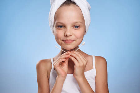 the girl in a towel smiles and holds the wand for the ears.の写真素材