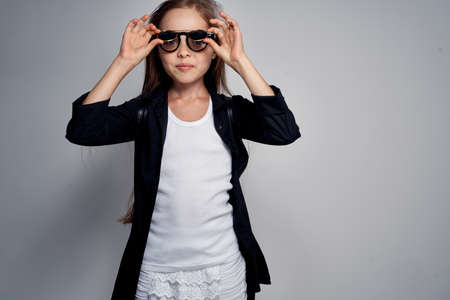 little girl with long hair straightens glasses.の写真素材