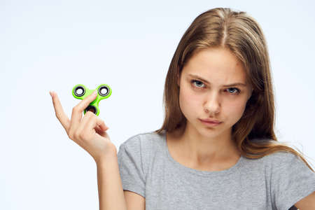 young woman holds a green spinner.の写真素材