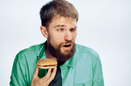 man holding a hamburger, emotions, portrait.の写真素材