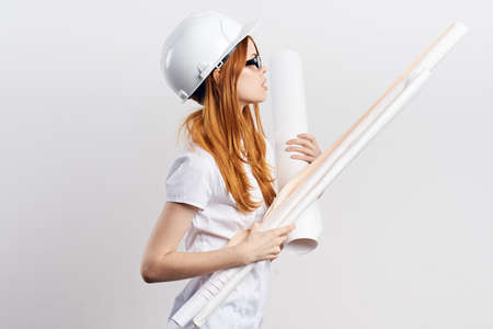 female engineer in helmet holds drawings, construction, layout.の写真素材