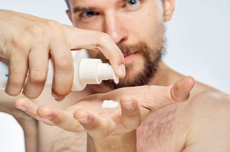 man applies cosmetic cream on hand, portrait.の写真素材