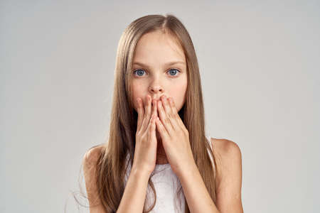 girl with long straight hair covered her face with her hands, portrait.の写真素材