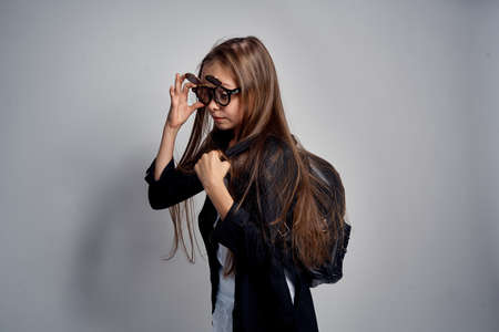 little girl with glasses with a backpack, long hair.